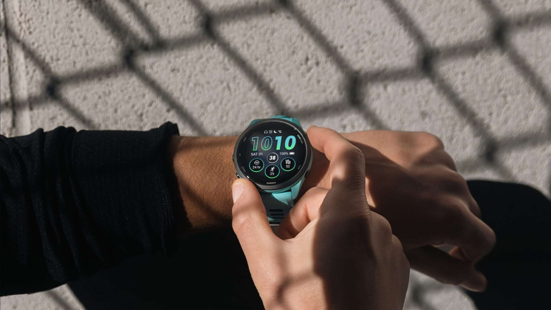 A Garmin Forerunner 265 on a user's wrist highlights the device's bright AMOLED display.